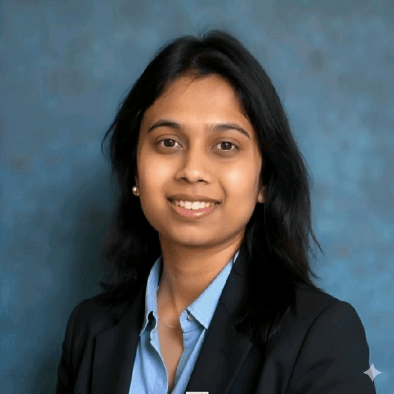 Portrait of Vishakha S, smiling, in a dark blazer over a light blue shirt